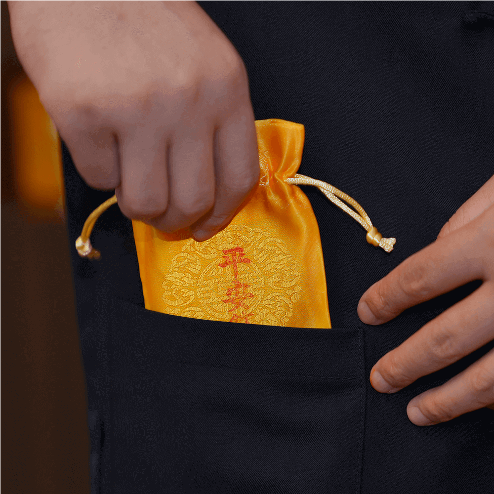 Safety Talisman charm being placed inside a clothing pocket for daily protection
