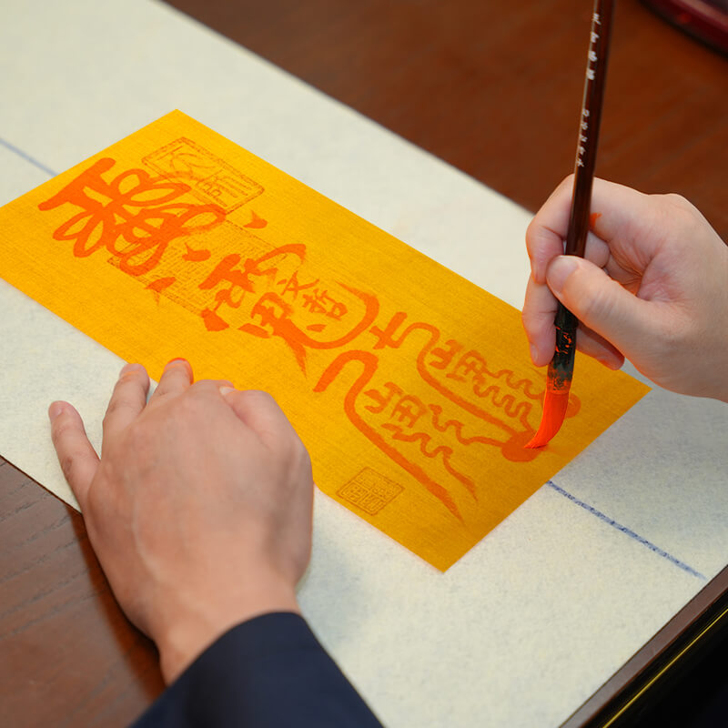 Taoist master hand-drawing a 2026 Fire Horse Tai Sui talisman during ritual preparation