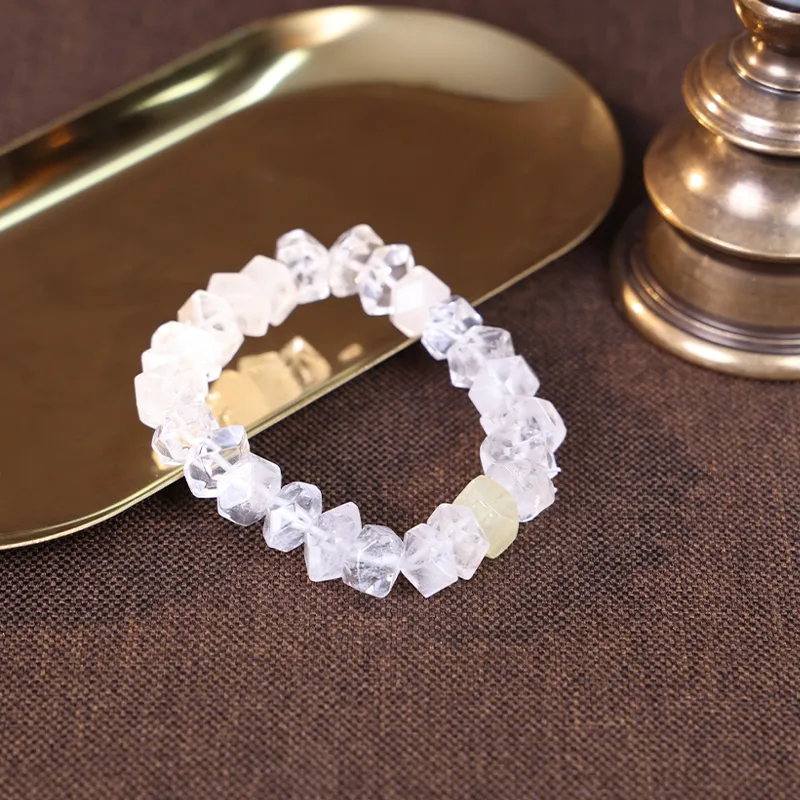 5 element crystal bracelet resting on a golden tray for radiance.