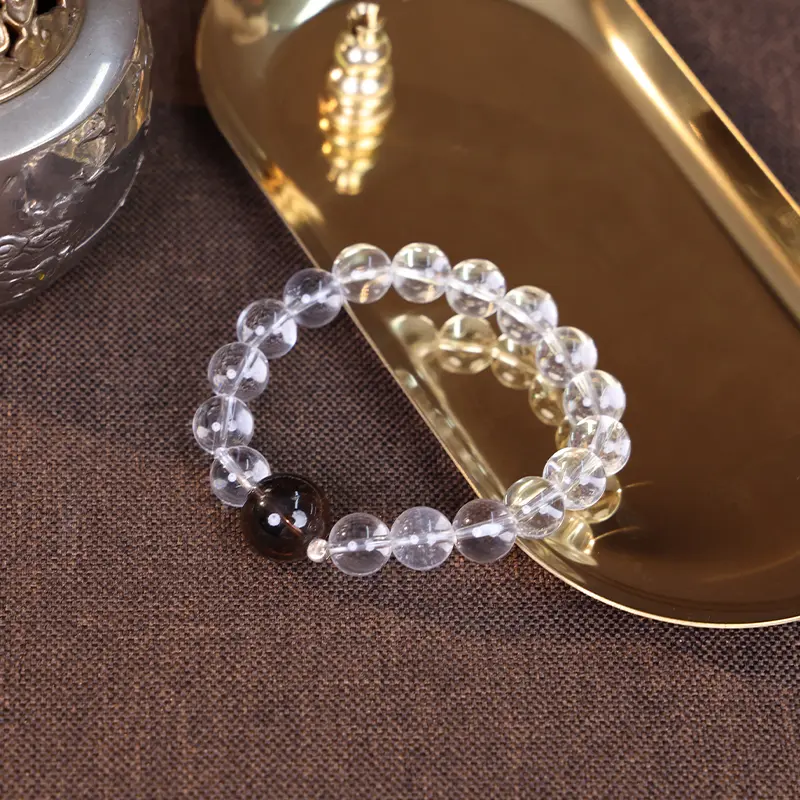 Metal element bracelet for balance displayed on a golden tray.