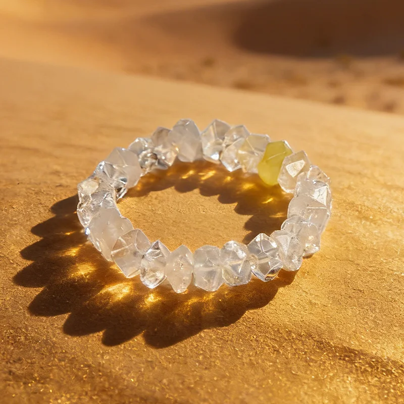 Natural white crystal bead bracelet glowing on golden desert sand.