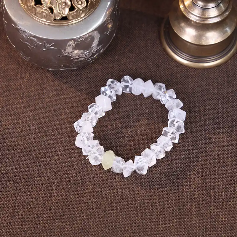 White crystal bead bracelet displayed with vintage brass props.