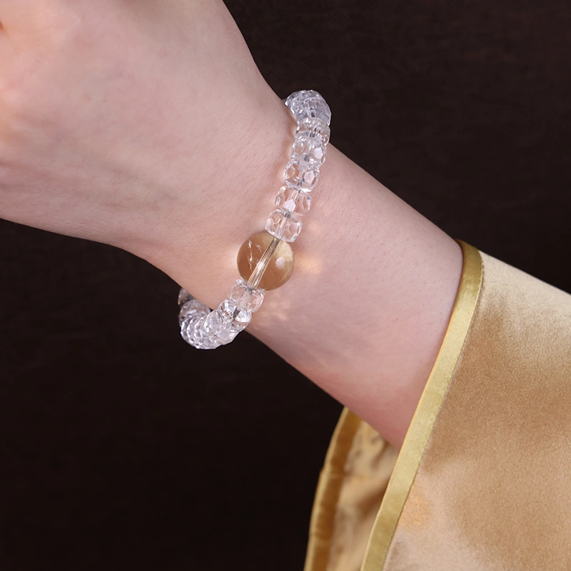 Close up of a white phantom quartz bracelet worn on the wrist.