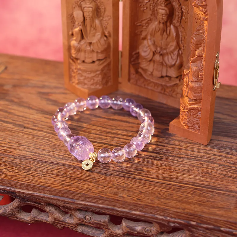 Amethyst pixiu bracelet as a wealth charm displayed on wood.
