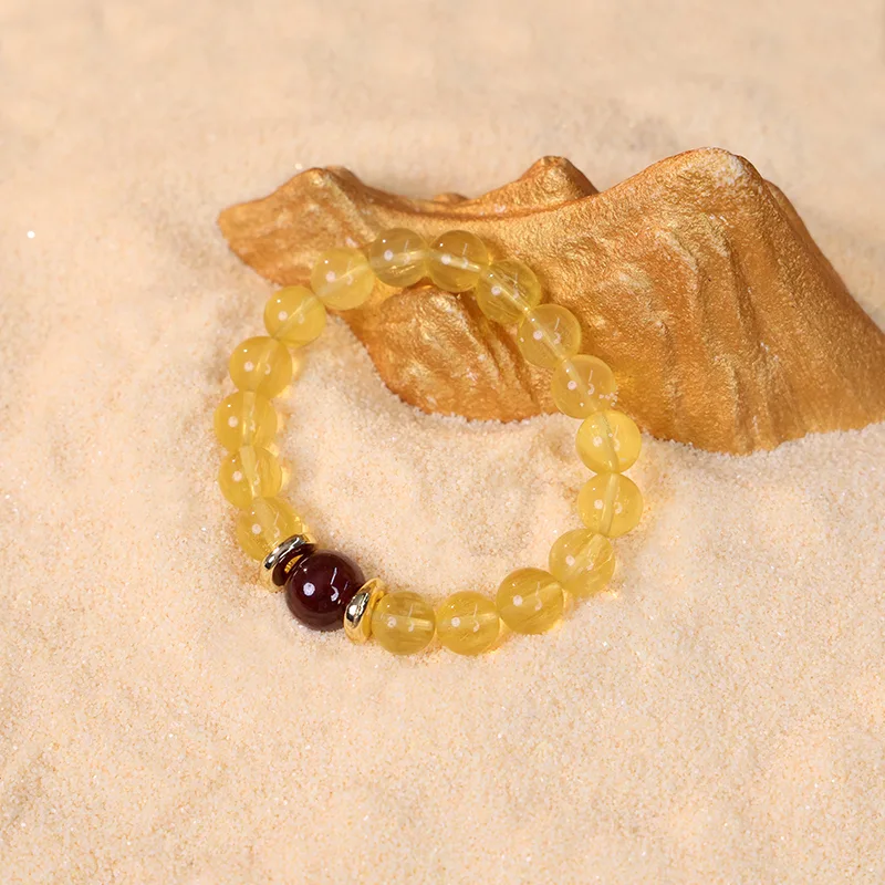 Custom motivational bracelets with yellow fluorite on natural sand.