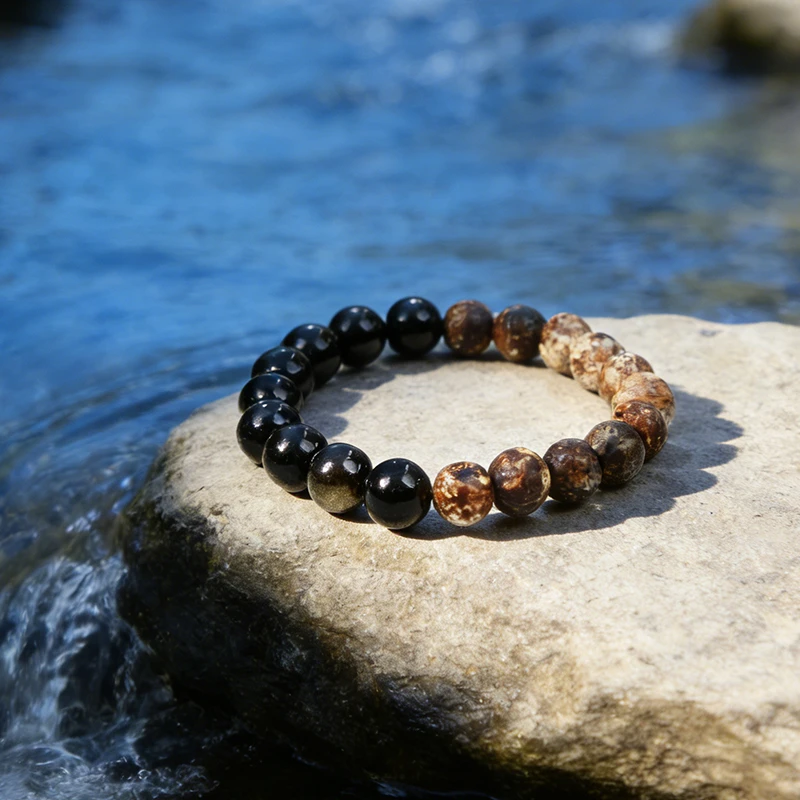 Natural emf protection bracelet resting on a rock in a water stream.