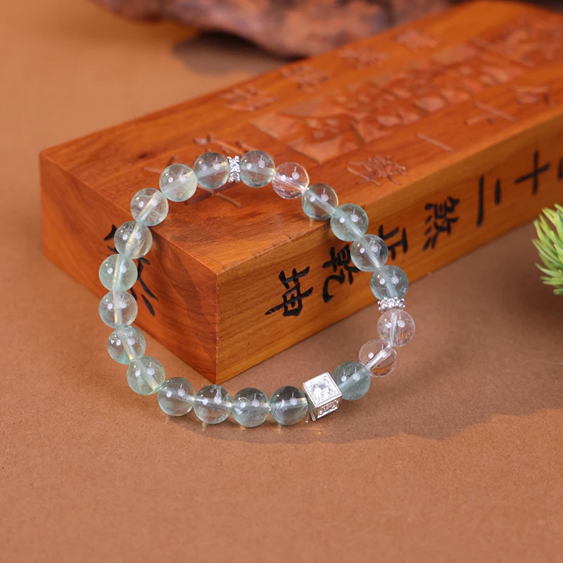 Green fluorite bracelet styled with an antique book for clarity.