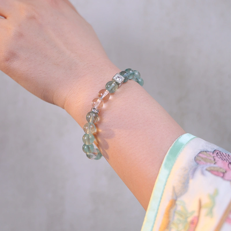 Close up of a green fluorite bracelet worn on the wrist.