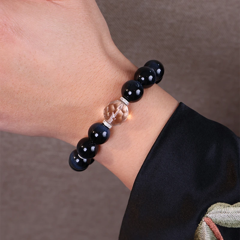 Close up of a Hawk's eye bracelet worn on a man's wrist.