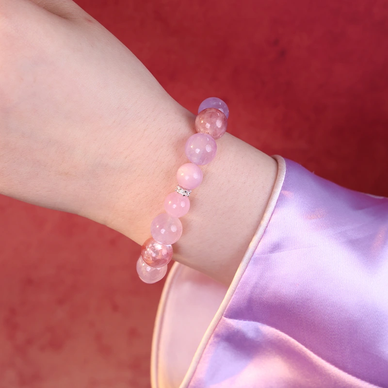 Close up of a lepidolite crystal bracelet worn on a woman's wrist.