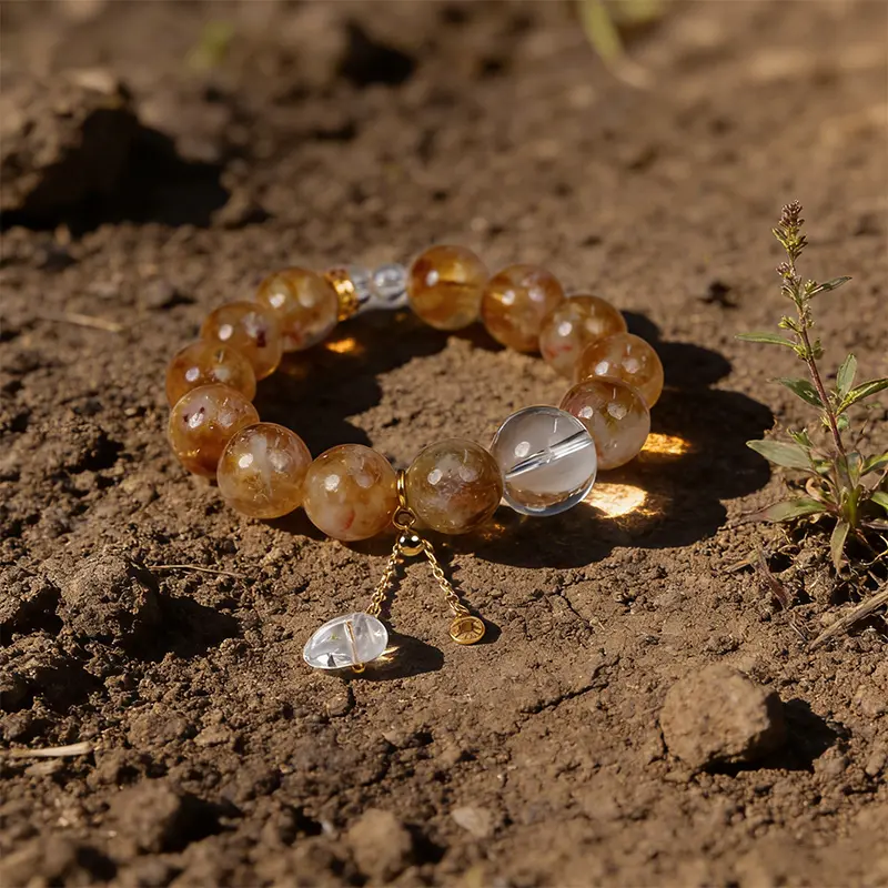 Natural yellow crystal good luck bracelet resting on real soil.
