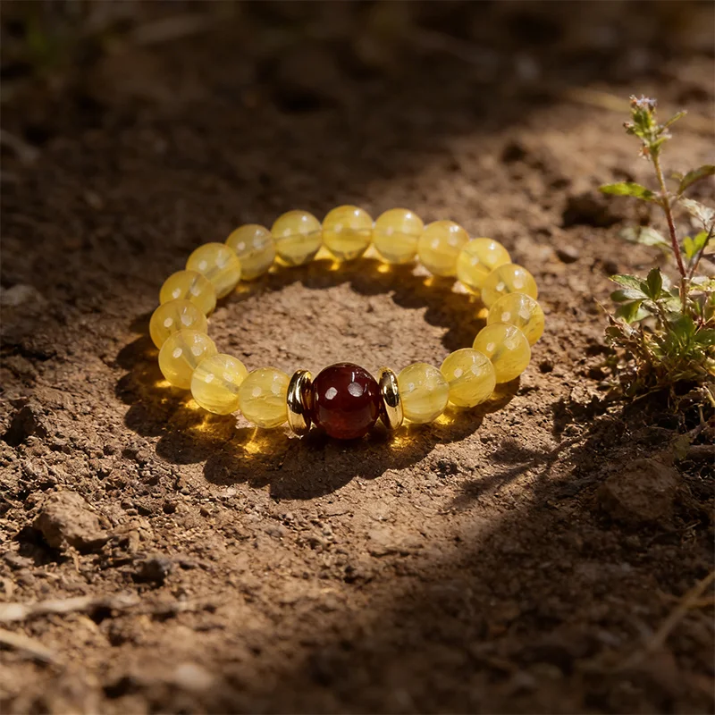 Natural yellow fluorite bracelet resting on real soil for earth energy.
