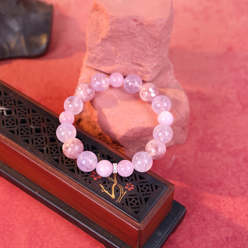 Purple lepidolite crystal bracelet on red silk background for harmony.