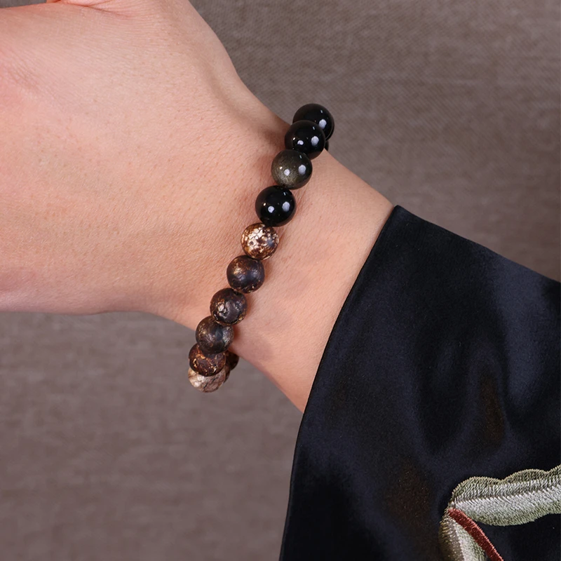 Close up of a tiger eye bead bracelet worn on a man's wrist.