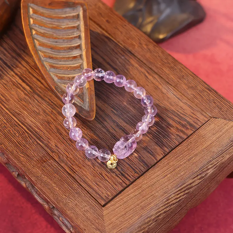 Wealth crystal bracelet with pixiu charm on traditional wooden props.