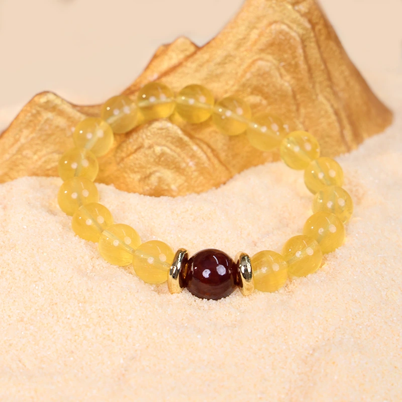 Yellow fluorite bracelet for balance styled on a sandy background.