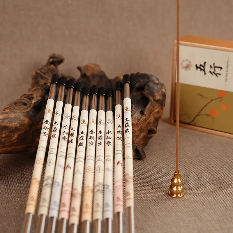 Incense stick burning in a brass holder.